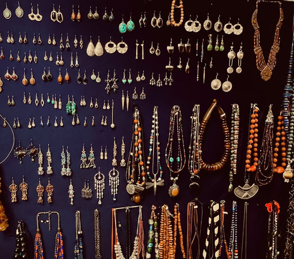 Collection of jewelry including necklaces and earrings on a dark background